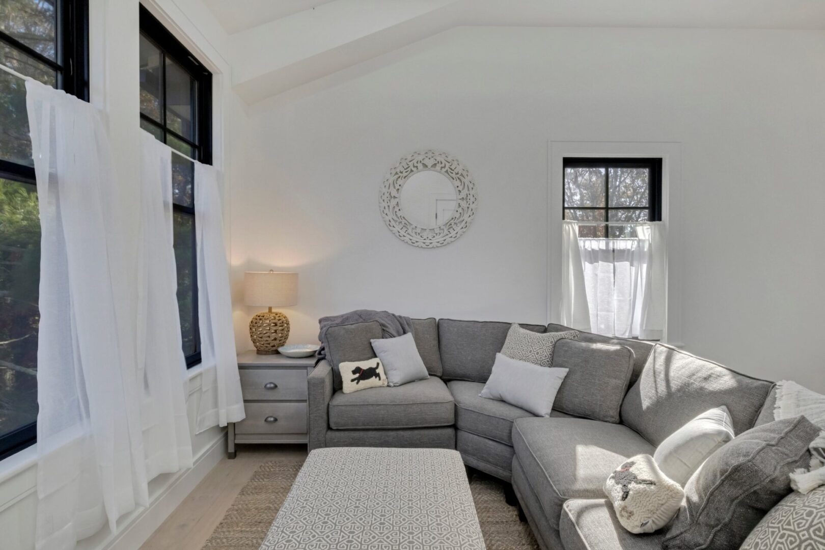 A living room with white walls and grey furniture.