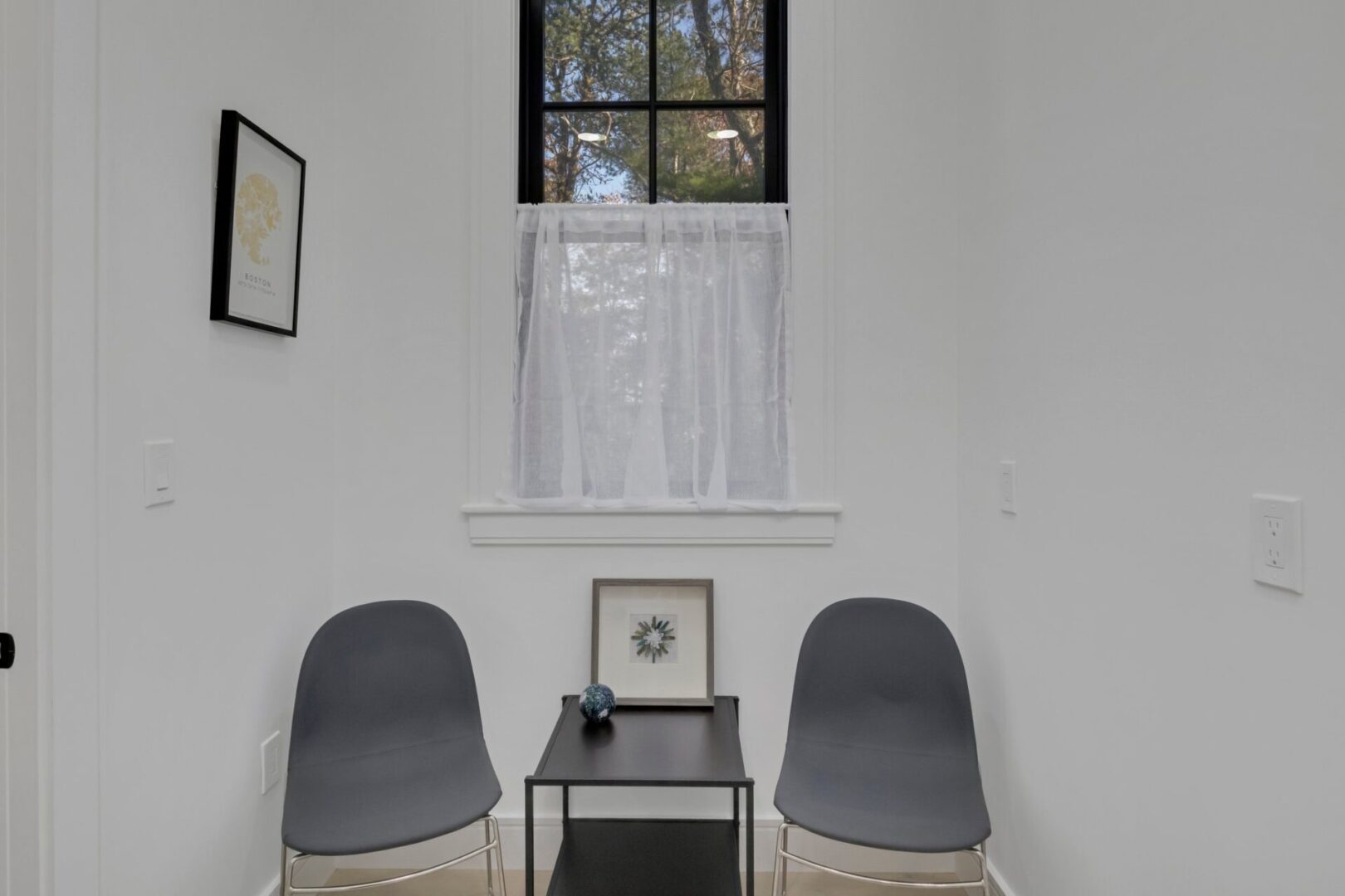 Two chairs and a table in front of a window.