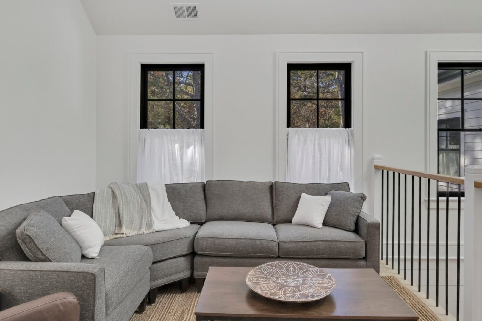 A living room with two windows and a couch